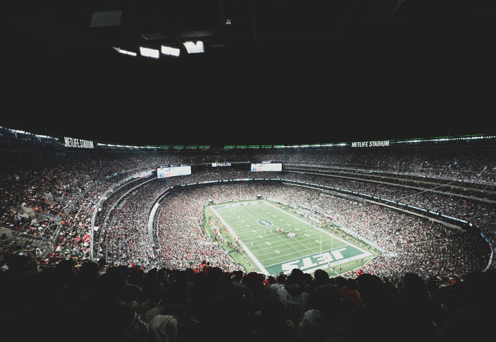 A packed stadium crowd under floodlights.